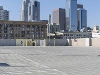 a black car parked on the concrete road in front of a cityscape in a parking lot