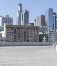 a black car parked on the concrete road in front of a cityscape in a parking lot