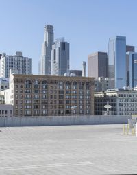 a black car parked on the concrete road in front of a cityscape in a parking lot