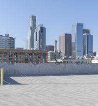 a black car parked on the concrete road in front of a cityscape in a parking lot