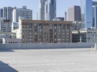 a black car parked on the concrete road in front of a cityscape in a parking lot