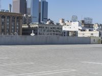 a black car parked on the concrete road in front of a cityscape in a parking lot