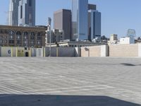 a black car parked on the concrete road in front of a cityscape in a parking lot