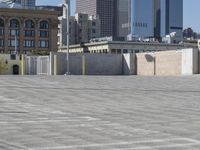 a black car parked on the concrete road in front of a cityscape in a parking lot