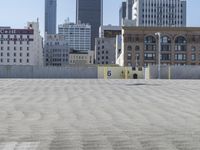 a black car parked on the concrete road in front of a cityscape in a parking lot