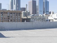 a black car parked on the concrete road in front of a cityscape in a parking lot