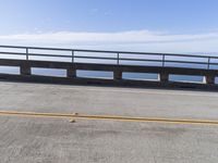 a couple of black skateboards sit on top of a ramp as the ocean sits next to a roadway