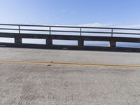 a couple of black skateboards sit on top of a ramp as the ocean sits next to a roadway