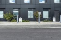 a black suv is parked outside the building next to street signs and trees that are on a sidewalk