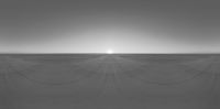 a person riding a skate board across a dirt field on a sunset day - looking towards the horizon