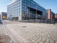 the large building is made of concrete and has metal railings around it, which are made of brick