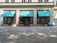 an empty area with two blue awnings outside and no chairs to sit in the front