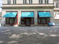 an empty area with two blue awnings outside and no chairs to sit in the front