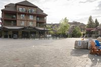 a blue chair is set on the square with the buildings behind it in front of them