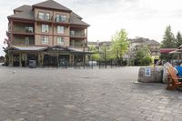 a blue chair is set on the square with the buildings behind it in front of them