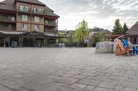 a blue chair is set on the square with the buildings behind it in front of them