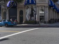 people are walking down the road near a store with blue and white awnings