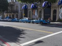 people are walking down the road near a store with blue and white awnings