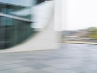 a blurry picture of an outside building with the reflection of a bus passing by