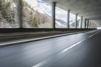 a blurry image of a road in an tunnel with rain, as viewed from the front seat of a car