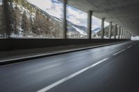 a blurry image of a road in an tunnel with rain, as viewed from the front seat of a car