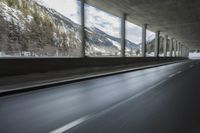 a blurry image of a road in an tunnel with rain, as viewed from the front seat of a car