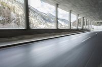 a blurry image of a road in an tunnel with rain, as viewed from the front seat of a car