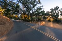 a blurry image of a highway surrounded by trees and a grass field with trees on either side