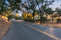 a blurry image of a highway surrounded by trees and a grass field with trees on either side