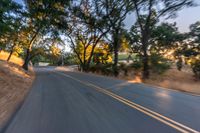 a blurry image of a highway surrounded by trees and a grass field with trees on either side