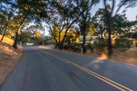 a blurry image of a highway surrounded by trees and a grass field with trees on either side