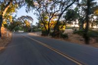 a blurry image of a highway surrounded by trees and a grass field with trees on either side
