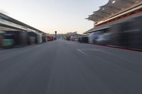 a blurry image of a bus moving in the distance near a terminal by itself