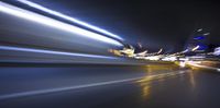 a blurry image of a long highway at night with light streaks coming from the cars headlights