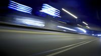 a blurry image of a long highway at night with light streaks coming from the cars headlights
