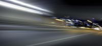 a blurry image of a long highway at night with light streaks coming from the cars headlights