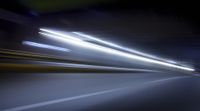a blurry image of a long highway at night with light streaks coming from the cars headlights