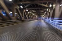 an image of a blurred pedestrian walkway in the night time with focus on the lights