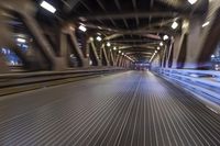 an image of a blurred pedestrian walkway in the night time with focus on the lights