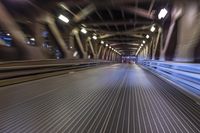 an image of a blurred pedestrian walkway in the night time with focus on the lights