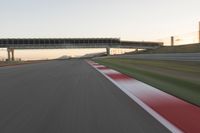 a blurry photo of a speed racing track with an overpass and bridge in the background