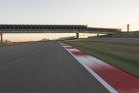 a blurry photo of a speed racing track with an overpass and bridge in the background