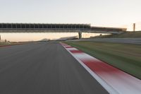 a blurry photo of a speed racing track with an overpass and bridge in the background