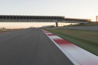 a blurry photo of a speed racing track with an overpass and bridge in the background