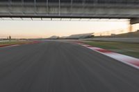 a blurry photo of a speed racing track with an overpass and bridge in the background