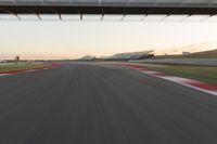 a blurry photo of a speed racing track with an overpass and bridge in the background