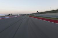 a blurry view of a race track with red and white stripes on the ground