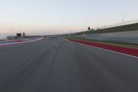 a blurry view of a race track with red and white stripes on the ground