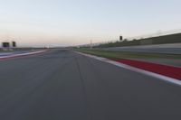 a blurry view of a race track with red and white stripes on the ground