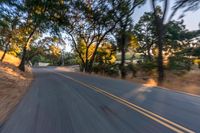 a blurred shot of some trees and a road in the background with a blurry image of an orange motorcycle